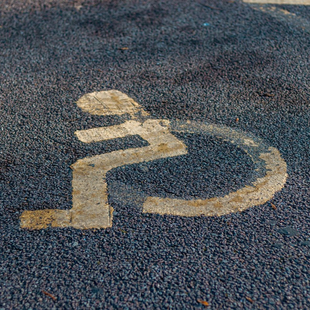 a handicap sign painted on the asphalt of a parking lot