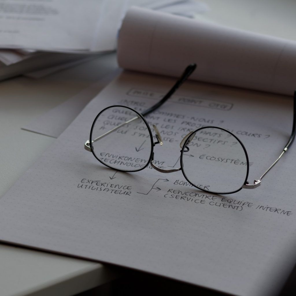 black framed eyeglasses on top of white printing paper